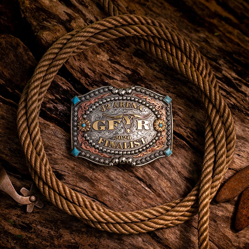 Custom Western Belt Buckle - A personalized belt buckle on a wood background with a cowboy rope